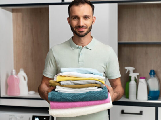 man holding pile clean clothes